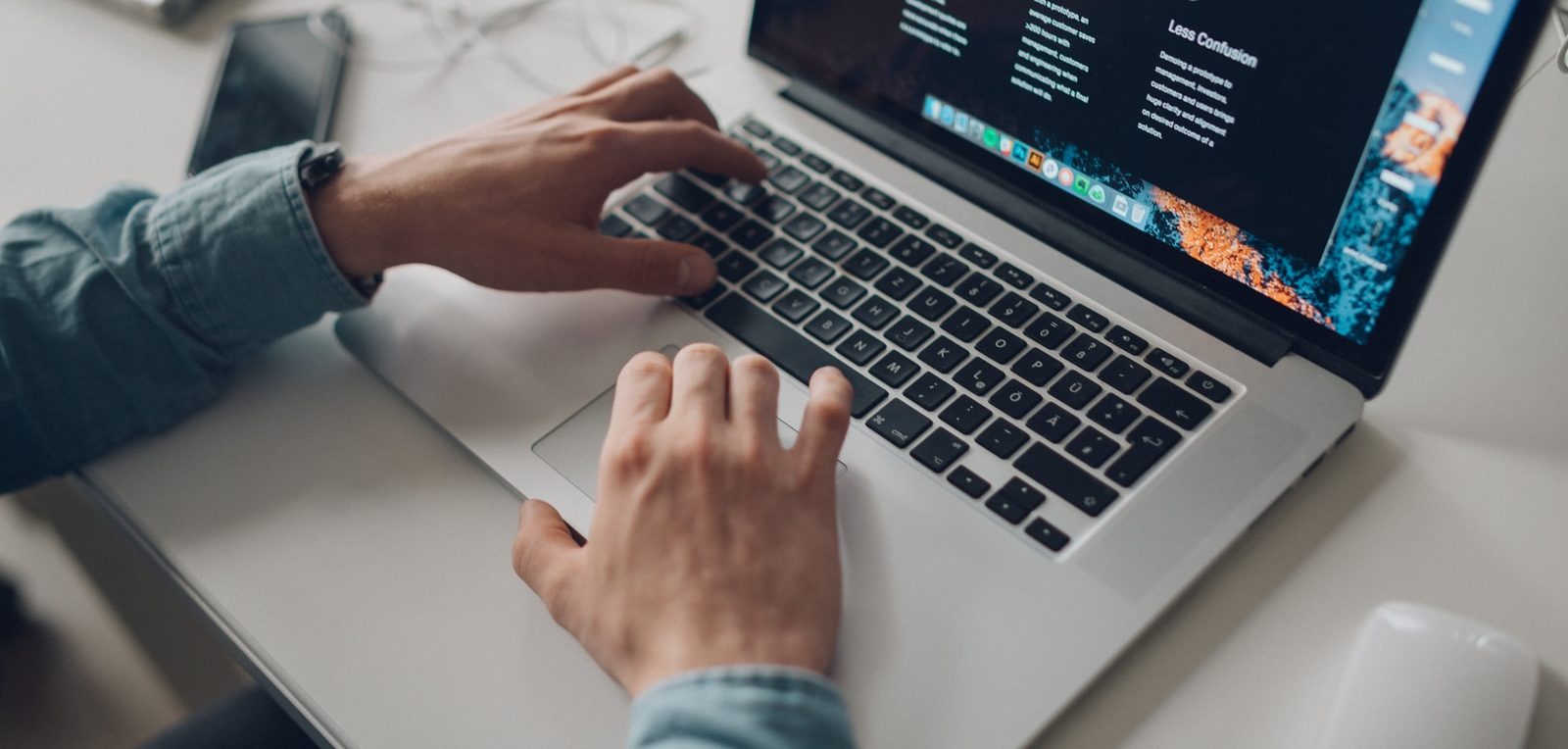 person wearing long-sleeve top working on laptop